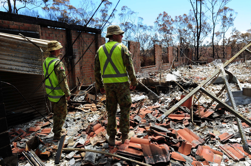 Australian Army Sappers, Rick Pepper (left) and Pete Monkley from the 17th Construction Squadron, inspect a ruined home prior to undertaking a "Make Safe" task in the fire affected area of Yellow Rock in the Blue Mountains, NSW. *** Local Caption *** The Australian Defence Force has stood up an Army Engineer Remediation Force (ERF) to assist the Blue Mountains community in its recovery from the recent bush fires in the area. Comprising Army Reserve members from the 5th Brigade and Australian Regular Army members from the 6th Brigade, the ERF will assess and ‘make safe’ properties and infrastructure damaged in the fires. This includes removing structural and environmental hazards. The ERF, which will include approximately 90 personnel, will be drawn from Army’s 5th Combat Engineer Regiment,17th Construction Squadron, 21st Construction Regiment and include equipment such as dump trucks, bulldozers, excavators, skid-steer and front end loaders, as well as teams of chain saw operators.