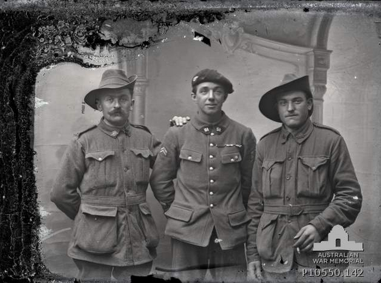 Group portrait of two unidentified Australians with a French soldier. The man on the left also appears in P10550.027. From the Thuillier collection of glass plate negatives. Taken by Louis and Antoinette Thuillier in Vignacourt, France during the period 1916 to 1918.
