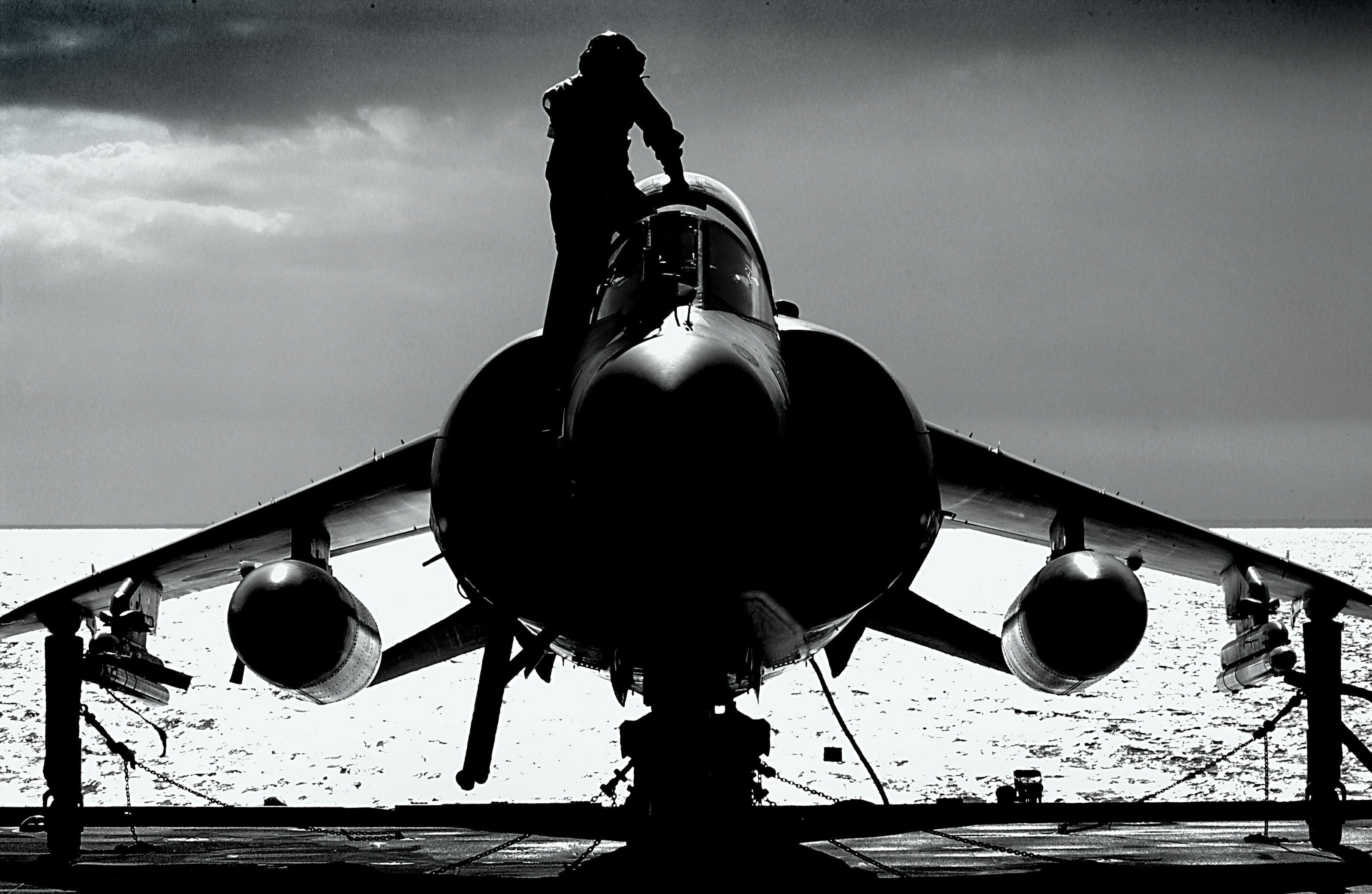 A pilot climbing into the cockpit of a Sea Harrier FA2, on the upper deck of HMS Illustrious, an Aircraft Carrier, as she sailed through the Straits of Gibraltar.
