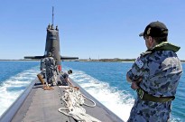 Petty Officer Electronic Warfare Submarines Bradley Smith on the submarine casing onboard HMAS Dechaineux as the boat departs from Diamantina Wharf at Fleet Base West.