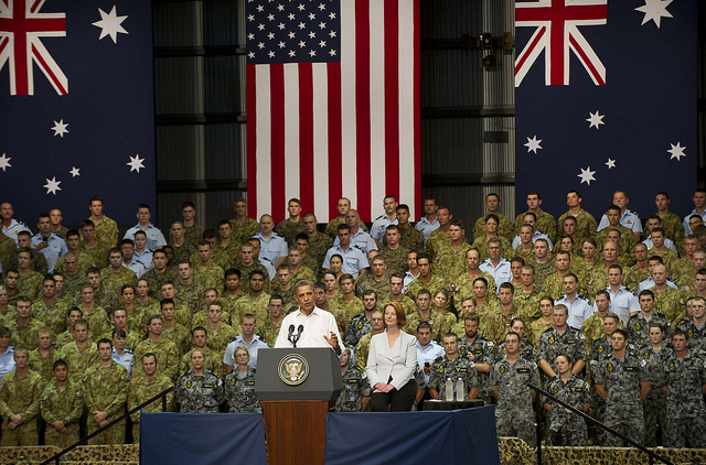Prime Minister Gillard listening to President Obama addressing troops in Darwin.  
