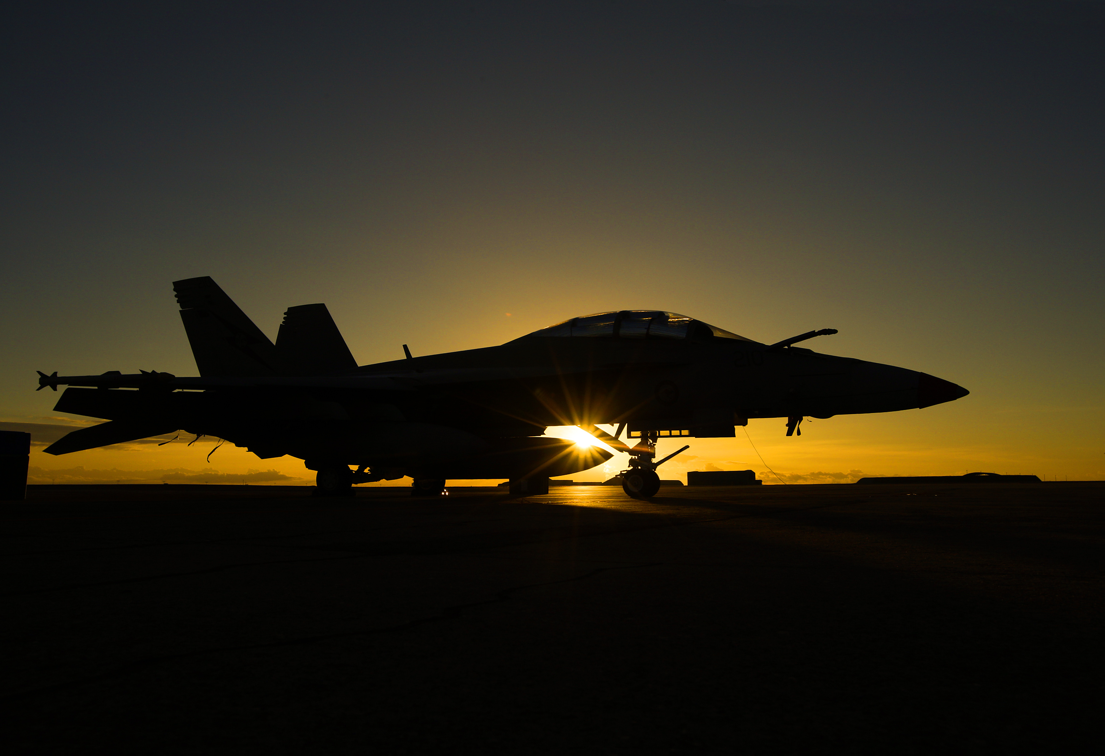 An F/A-18F Super Hornet catches the early morning rays of a Territory sunrise on the flightline at RAAF Base Darwin.