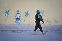 A Nigerian policeman walks by a newly built wall on a foot patrol near Lido beach in Somalia's capital, Mogadishu.