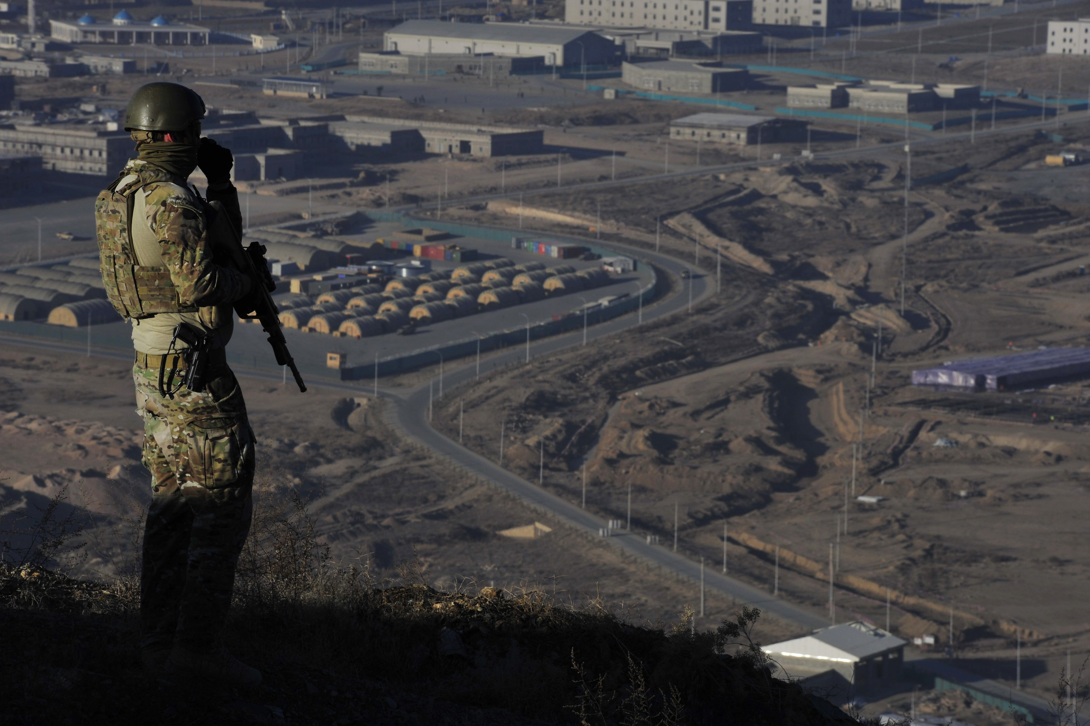 Trooper Stuart Dickson stands watch on a hilltop that overlooks the Afghan National Army Officer Academy on Christmas Morning, 2013. 