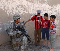 U.S. Army Staff Sgt. Robert Montez, with Alpha Company, 2nd Battalion, 16th Infantry Regiment, 2nd Brigade Combat Team, 1st Infantry Division, speaks with local kids during a patrol through the Mashtal area of East Baghdad, Iraq, March 13, 2007. (U.S. Army photo by Spc. Davis Pridgen) www.army.mil