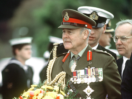 "GEN Sir Phillip Bennett, royal governor of Tasmania, prepares to place a wreath at a memorial during a service, part of ceremonies commemorating the 50th anniversary of the Battle of the Coral Sea." (May 1982)