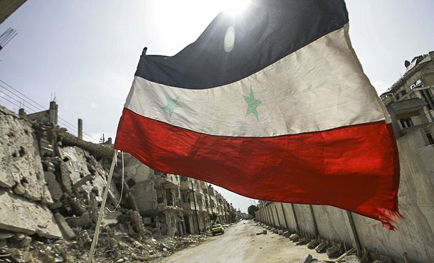 A Syrian flag flutters outside a militar