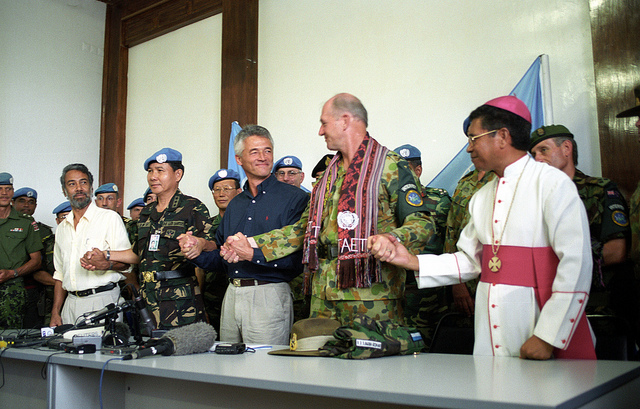 Commander INTERFET, MAJ GEN Cosgrove joins hands with the new East Timor leadership during a celebration to mark the official handover from INTERFET to UNTAET