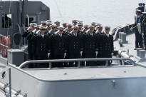 Graduates of the Japan Maritime Self-Defense Force (JMSDF) Officer Candidate School salute their instructors and family members as they prepare to sail off to their prospective ships.