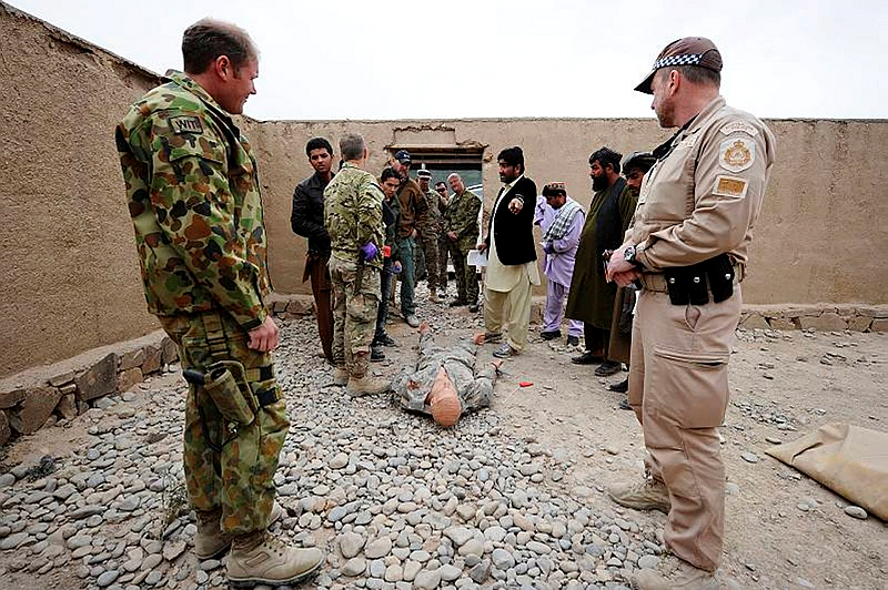 Australian Defence Force Investigative Service Sergeant Ben Gilbey (left) and Australian Federal Police Sergeant Nathan Thompson watch as Afghan National Police and Criminal Investigation Division members work a crime scene during Evidence Based Police Operations training held at Multi National Base - Tarin Kot, Afghanistan.