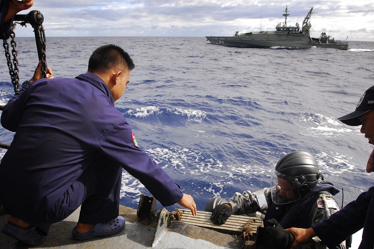 Following a successful boarding exercise, HMAS Maryborough's Petty Officer Bosun Michael Cunnington, is assisted by an Indonesian sailor at the completion of a boarding exercise with Indonesian Warship KRI Wiratno during the first Australian-Indonesian Coordinated Patrol.