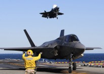 An aviation boatswain’s mate maneuvers BF-04, front, the U.S. Marine Corps variant of the F-35B Lighting II