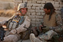 Afghan National Army soldier Taza Khan hands a bag of beef jerky to a local boy, injured by an improvised explosive device, while patrolling with U.S. Marines from 3rd Platoon, Lima Company, 3rd Battalion, 3rd Marine Regiment during Operation Tageer Shamal (Shifting Winds) on 5 January 2012.