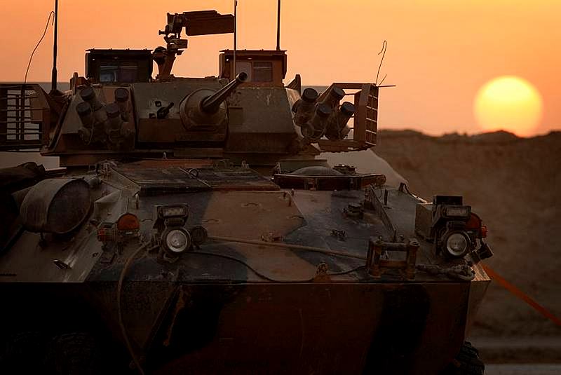 An Australian Light Armoured Vehicle (ASLAV), stands in the light of sunset.