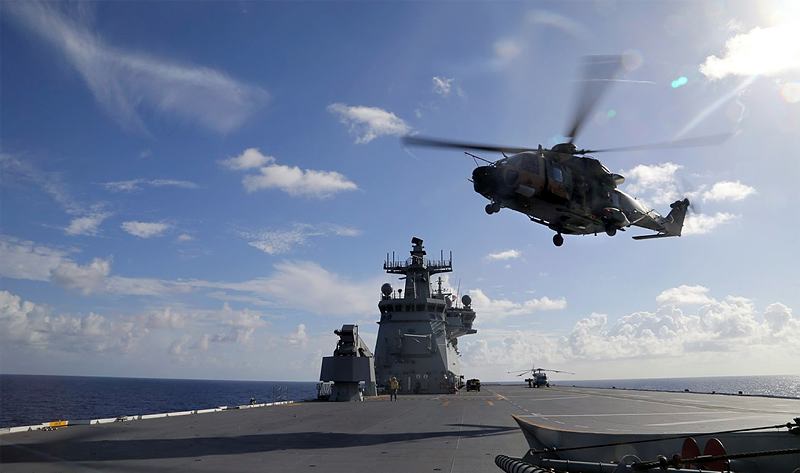 A MRH-90 Taipan helicopter, conducts a vertical replenishment during First of Class Trials, onboard HMAS Canberra.