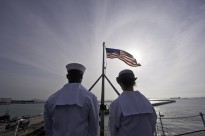 SINGAPORE (Jan. 30, 2012) Airman Joseph White, left, and Aviation Boatswain's Mate (Handling) Airman Kelsey Lefler stand by to lower the ensign as the Nimitz-class aircraft carrier USS John C. Stennis (CVN 74) departs Singapore. J