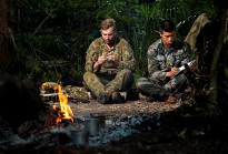Australian Army officer Lieutenant Lachlan Joseph (left) makes a fishing lure, while People’s Liberation Army of China officer Lieutenant Huang Jin Long updates his journal during the survival phase of Exercise Kowari 2014 in remote Northern Territory bushland.
