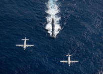 Two P-3 Orion anti-submarine and maritime surveillance aircraft from the Japan Maritime Defense Force, left, and the U.S. Navy, right, fly over the Los Angeles-class attack submarine USS Houston