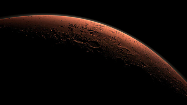 This computer-generated view depicts part of Mars at the boundary between darkness and daylight, with an area including Gale Crater beginning to catch morning light.   Gale Crater looms in the distance, distinguished from adjacent craters by its central mountain of strata. Gale Crater straddles the dichotomy boundary of Mars, which separates the broad, flat, and young northern plains from the much older and rougher southern highlands. There is evidence that water may have flowed across this topographic boundary, from highland to lowland, perhaps pooling locally within Gale Crater and forming the lowermost strata that fill the crater.