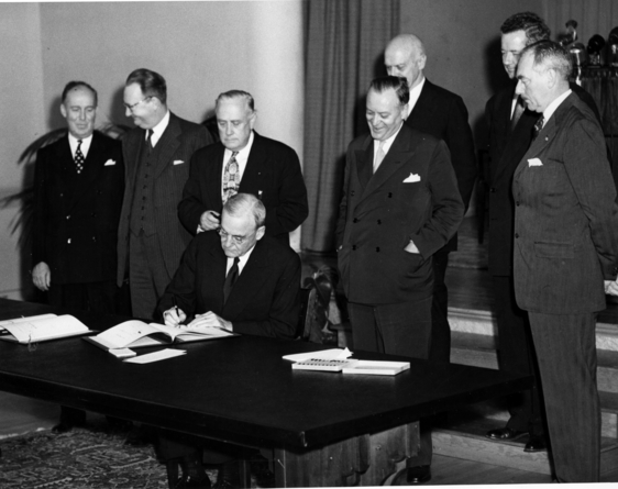John Foster Dulles is shown signing the Tripartite Security Treaty