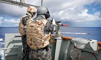 Able Seaman Boatswains Mate Rory Dow (right) takes aim on a "hostile" target with the 12.7 mm gun during a damage control exercise onboard HMAS Success while in transit to the Middle East as part of Operation MANITOU.