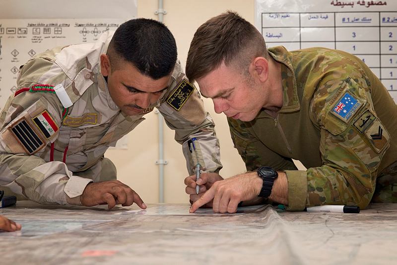 Task Group Taji Australian Army trainer Corporal Jeffrey Cummings confirms with a regular Iraqi Army soldier how to accurately mark and gauge distances during a navigation lesson at the Taji Military Complex in Iraq.