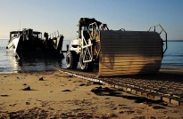 An Australian Army vehicle lays a protective mat over the beach at Sabina Point prior to other vehicles coming ashore from HMAS Choules in Shoalwater Bay, Queensland, as part of Exercise Talisman Saber 2013.
