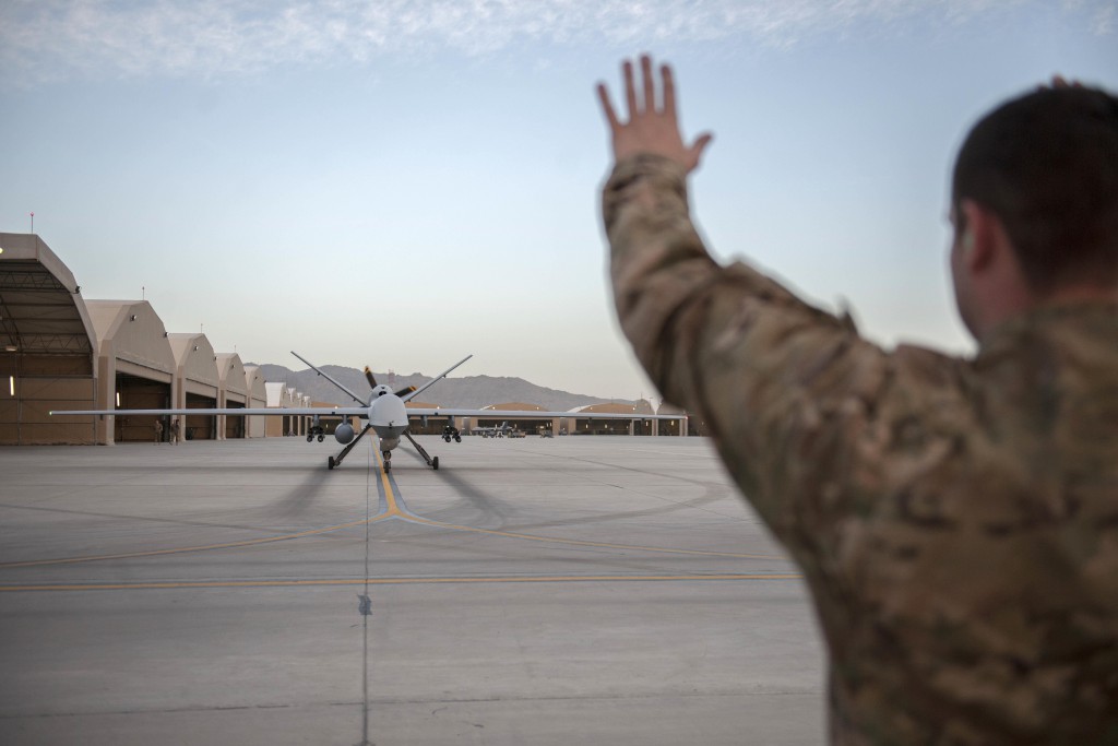 U.S. Air Force Senior Airman Christopher uses hand signals to marshal an MQ-9 Reaper for end-of-runway checks on Kandahar Airfield, Afghanistan, Dec. 6, 2015. U.S. Air Force photo by Tech. Sgt. Robert Cloys 